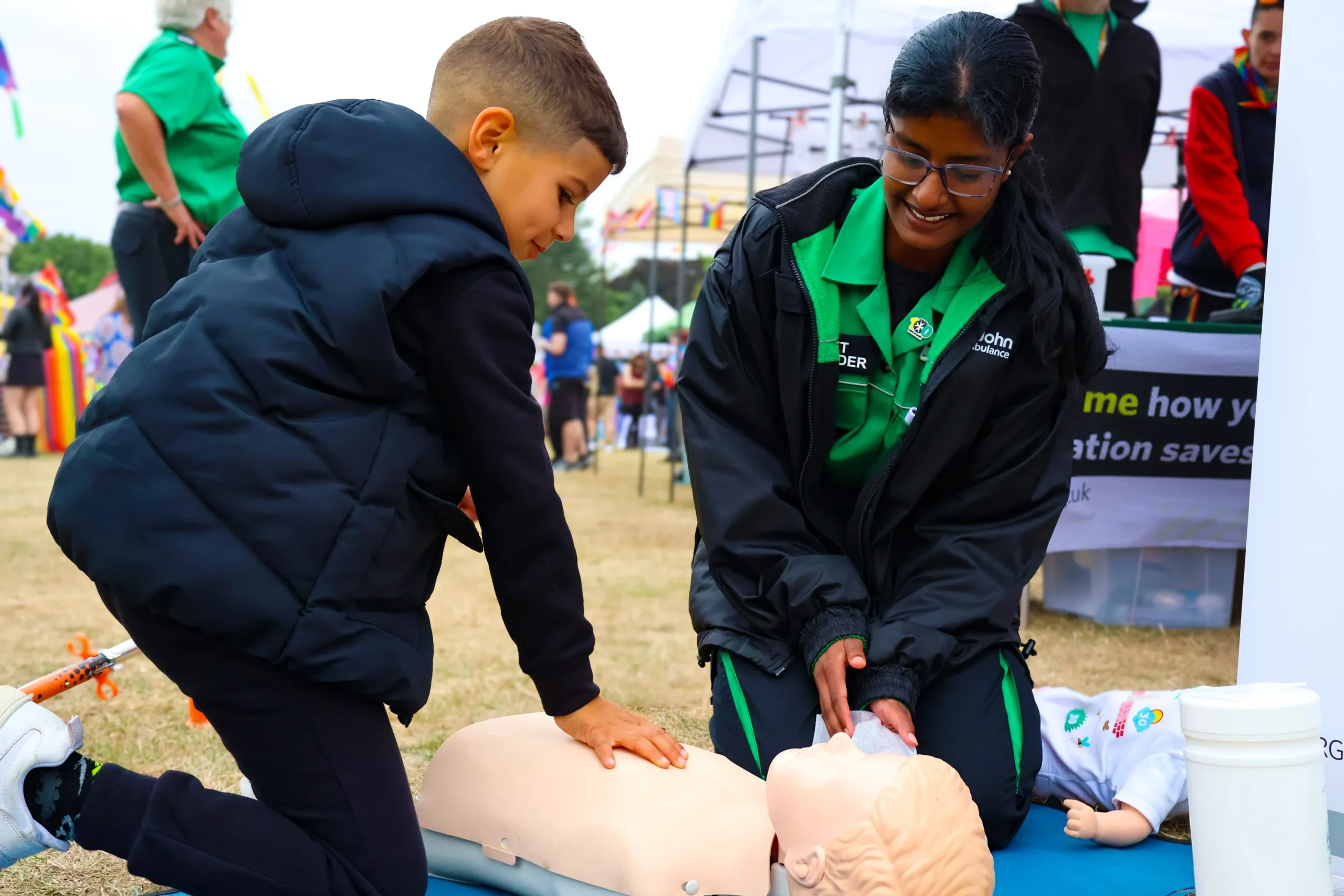 St John cadet teaching first aid to children at a school event